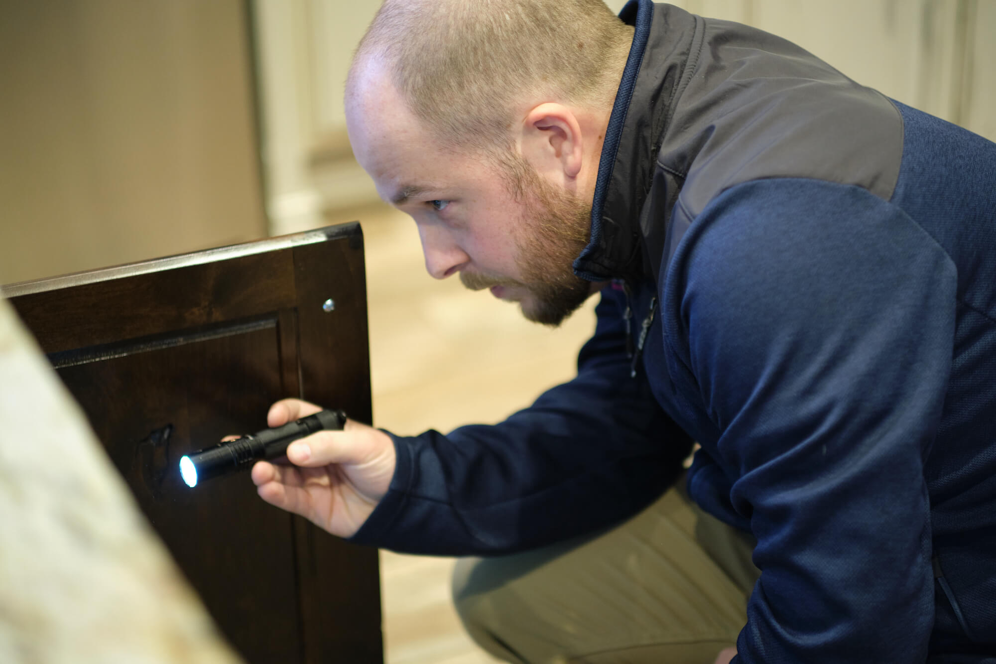 Home inspector looking into cabinet