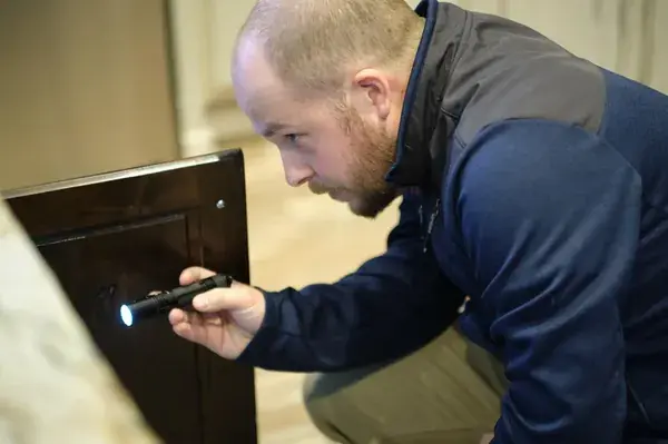 Home inspector looking into cabinet